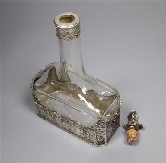 A late 19th/early 20th century German Hanau white metal mounted glass decanter, with figural stopper, 23.8cm.